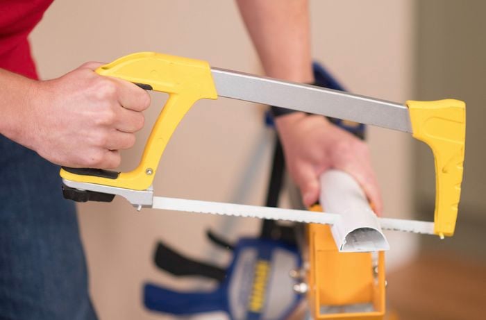 Cutting the cover to the appropriate size with a hacksaw.