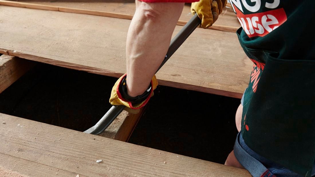 Close up of a Bunnings team member to pry up a floorboard using a crowbar