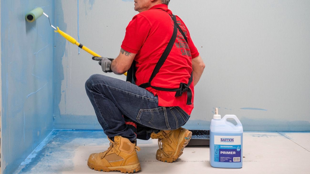 Bunnings team member applying primer on a wall using a roller