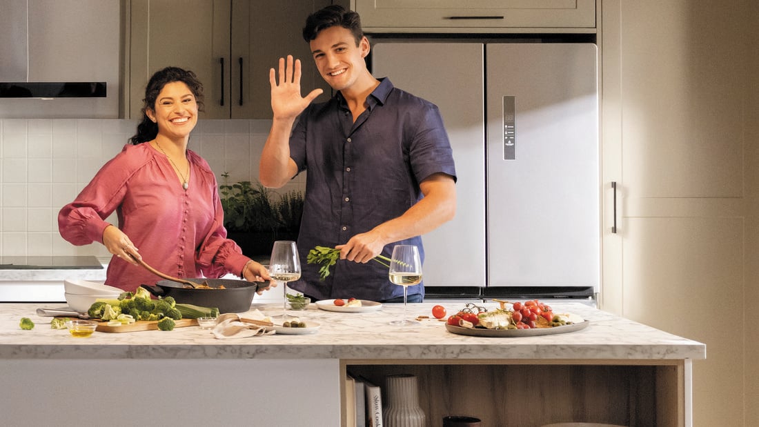Man and woman standing in the kitchen preparing dinner