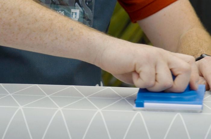 Person smoothing wallpaper with a float
