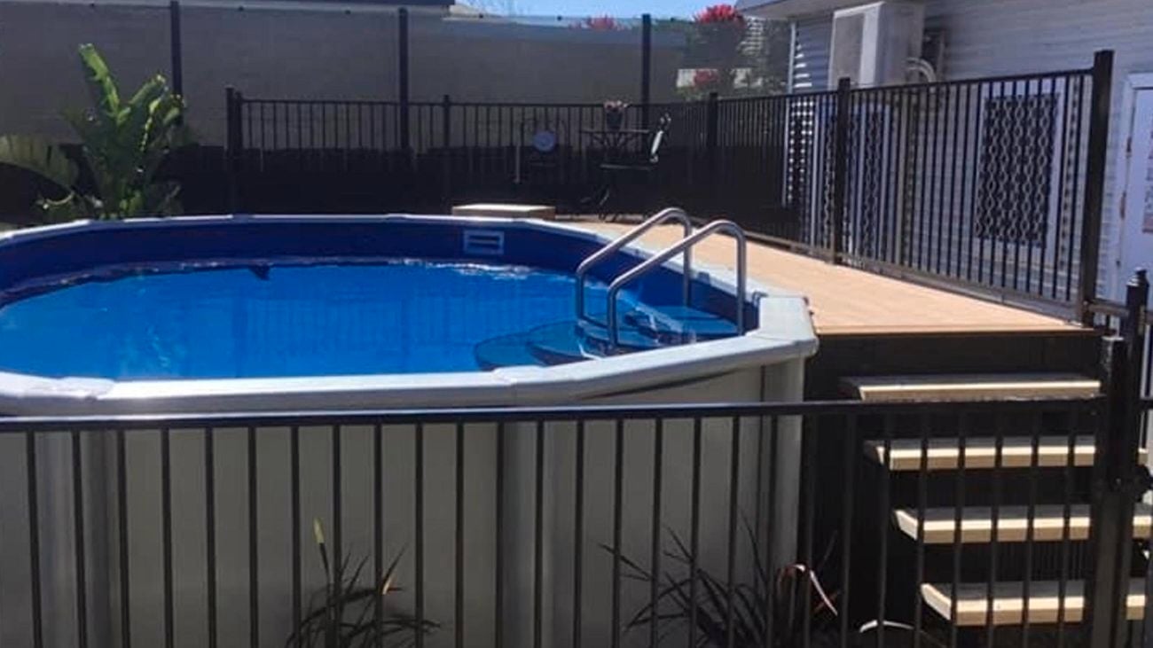 An above ground pool in a backyard with a fence around it