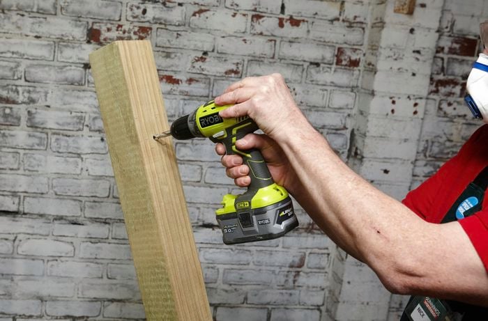 Person drilling into piece of timber.