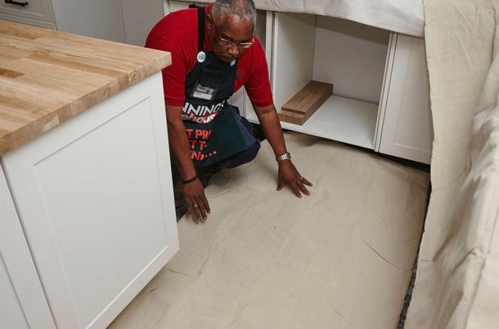 Person laying drop sheet on the ground.