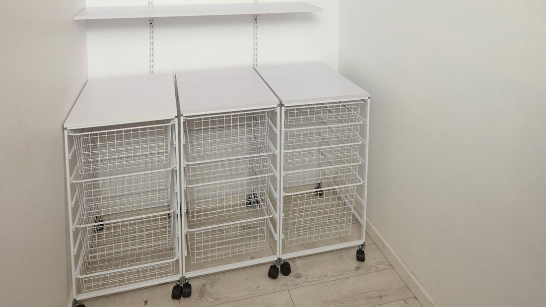 A linen closet with wire baskets trolleys
