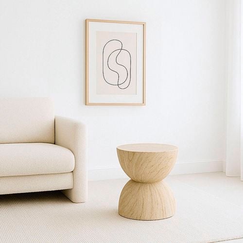 This hourglass side table features a sculptural double-cone shape in natural wood for a warm, organic touch.