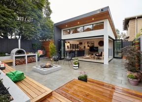 Modern house with open living area adjoining a paved outdoor entertaining area