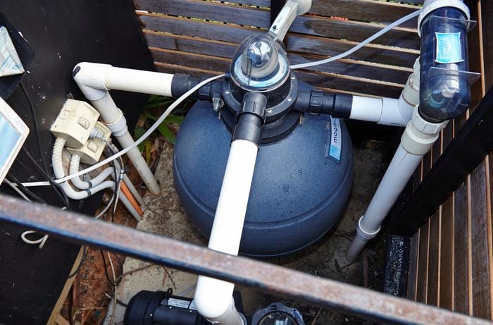 A pool pump sitting in a purpose built enclosure