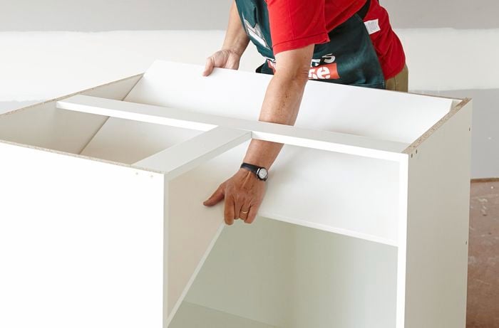 Person placing shelf into cabinet