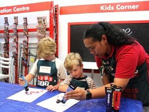 Bunnings team member and children painting.