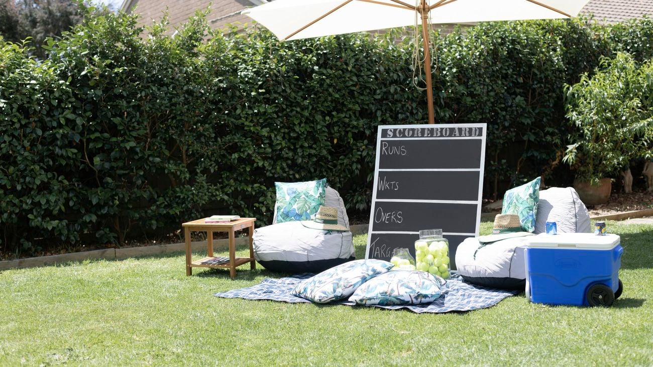 Chalk scoreboard in a backyard leaning on an umbrella