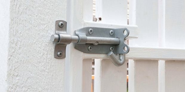 A Pinnacle galvanised padbolt on a white gate.
