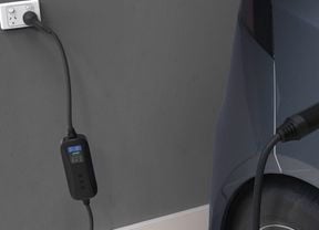 A Deta portable electric vehicle charger model with screen plugged into a car
