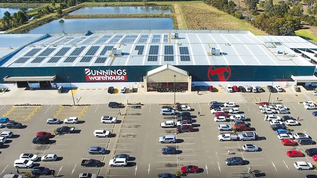 Many cars in the car park out the front of a Bunnings Warehouse.