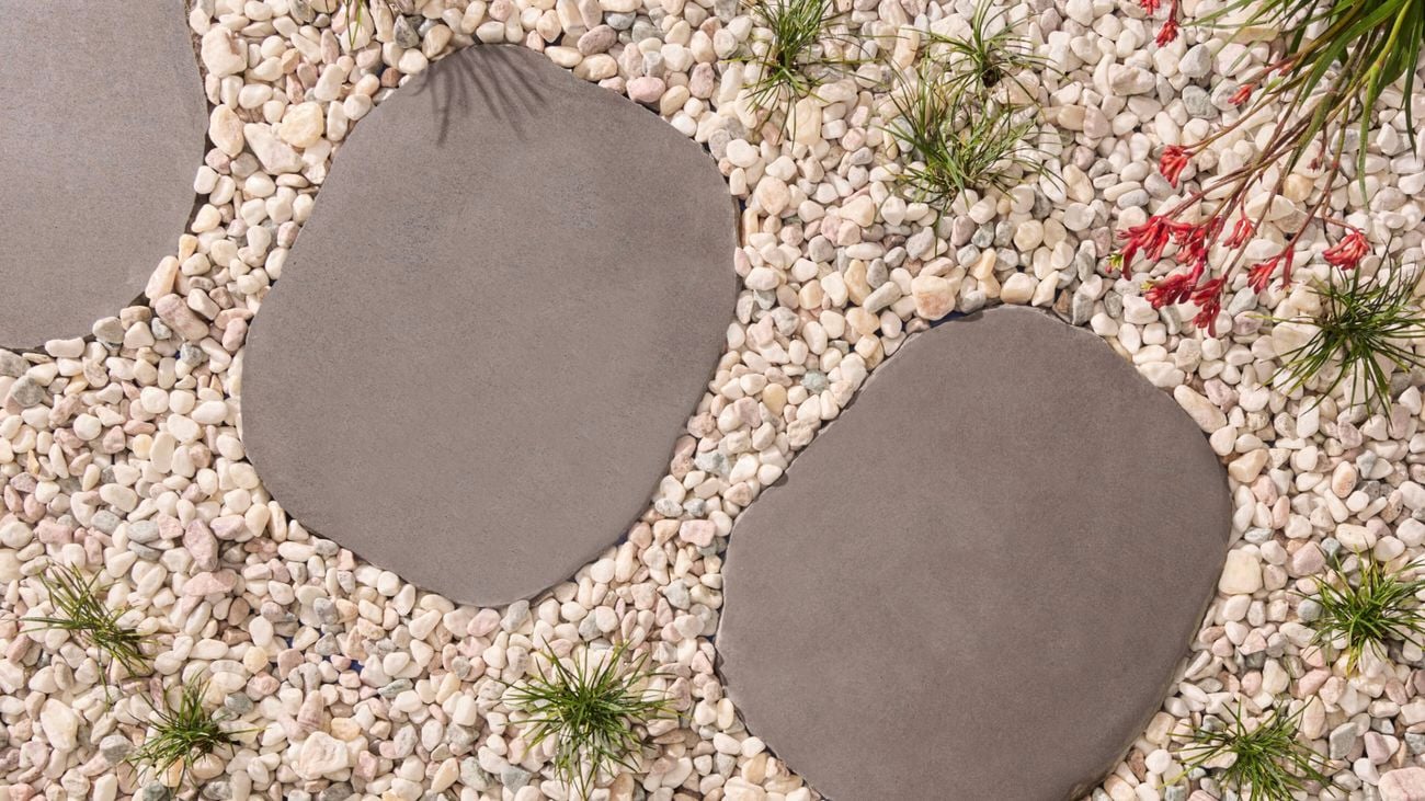 A picturesque stone pathway adorned with smooth pebbles and vibrant plants, creating a peaceful outdoor ambiance.