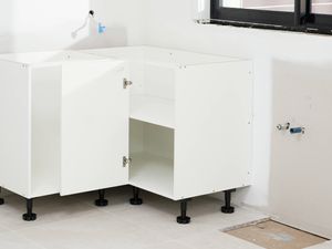 The image shows two assembled corner base cabinets installed side by side, with doors open to reveal internal shelving.