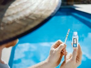 Man testing the water of his pool with Hy-Clor products