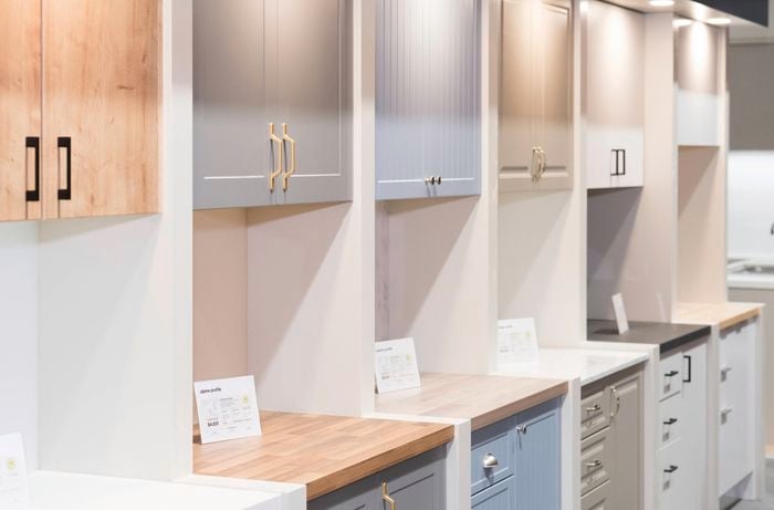 The image shows a kitchen displays in-store of various cabinet and benchtop styles.