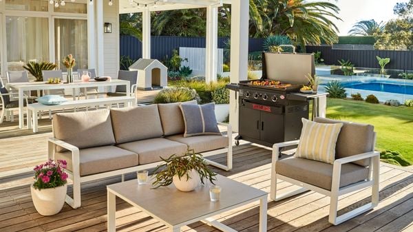 Outdoor setting, barbecue, dog house, outdoor table and a pool in an outdoor area at the back of a house.