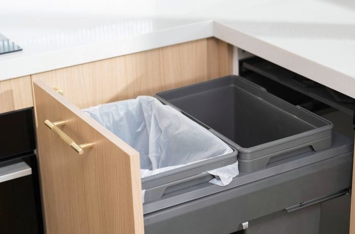 Smart storage transforms kitchen functionality—like pull-out cabinets with dual bins for easy waste and recycling separation.   