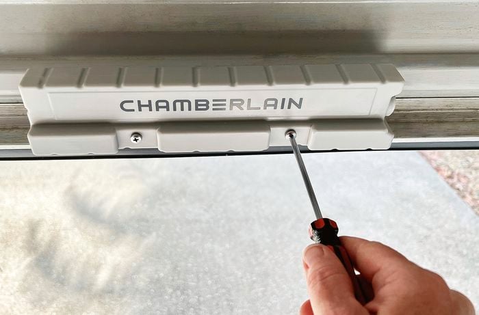 Persons hand uses screwdriver to secure bolts on Chamberlain.