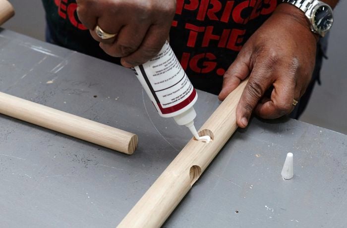 Foot rails being glued into place in a bar stool leg