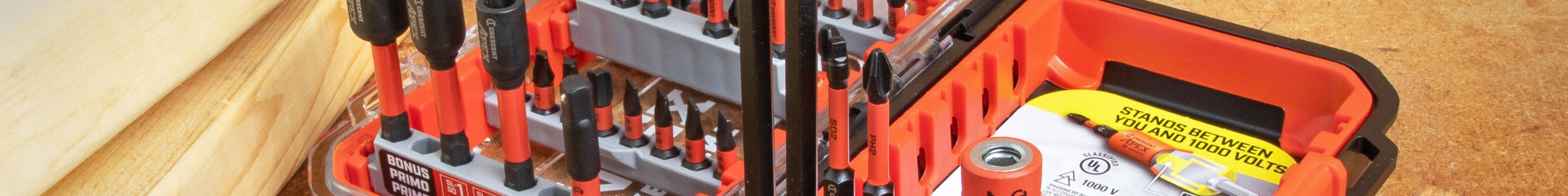 Insulated screwdriver bit set and impact driver arranged on a workbench with timber and fasteners.