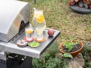 Drinks on coasters on the side of a BBQ