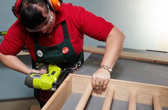 Person using nail gun to nail piece of timber together