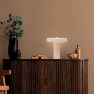Wooden cabinet with decorative items and a flat shaped lamp lit up
