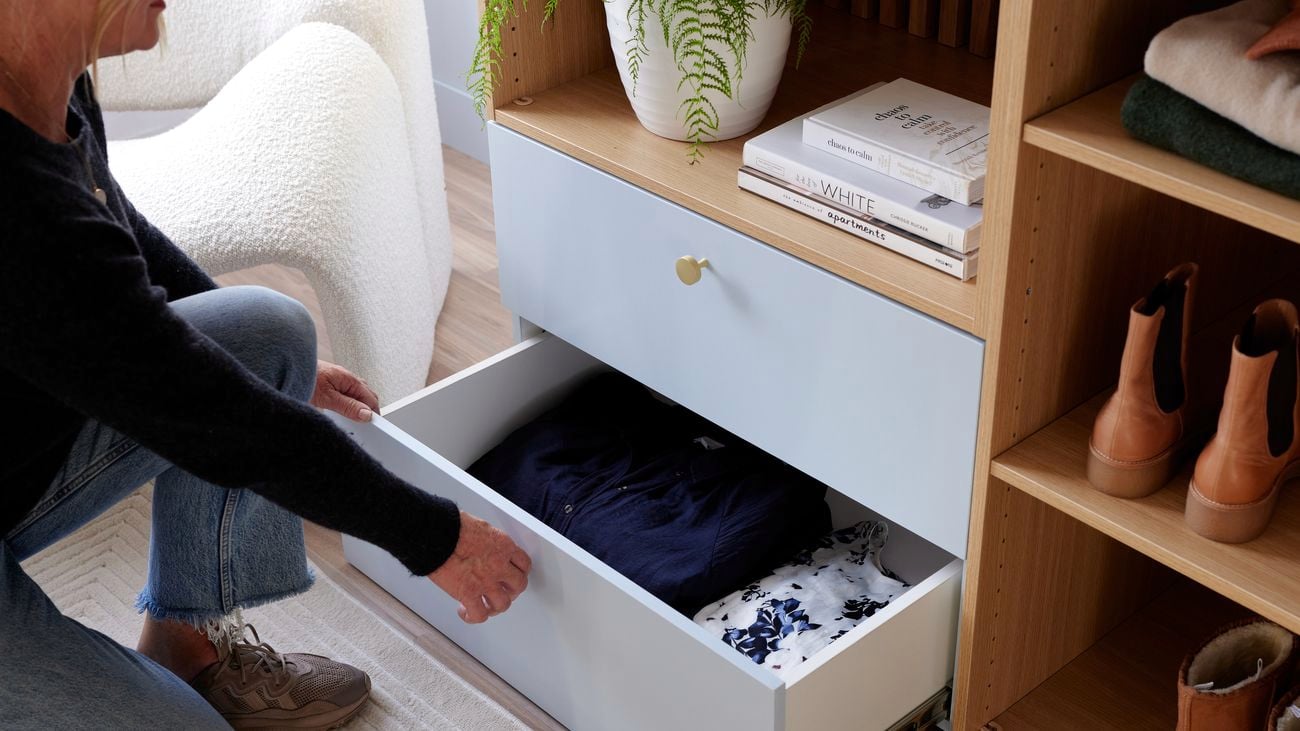 Lady pulling out drawers with clothes inside from Lugna unit.