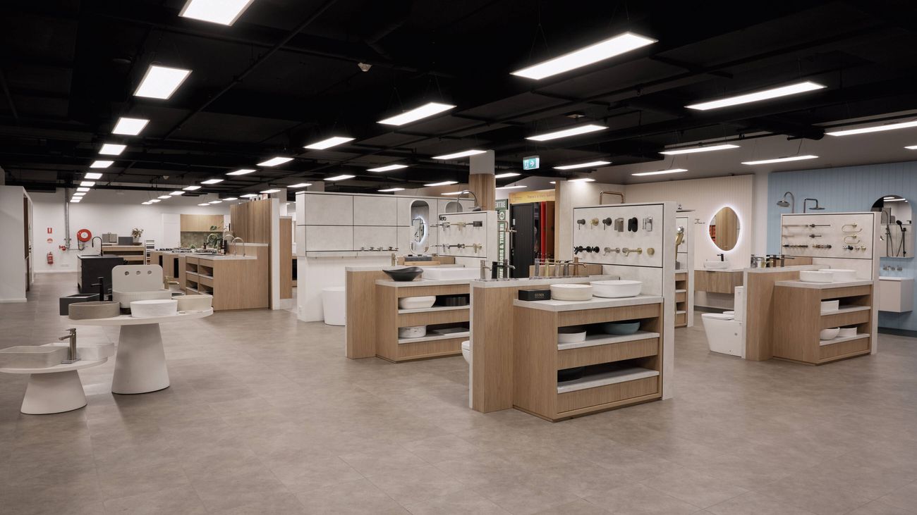 A Bunnings Solutions Studio showroom displaying various bathroom fixtures, including sinks, vanities, and toilets, with multiple display units arranged throughout the area.