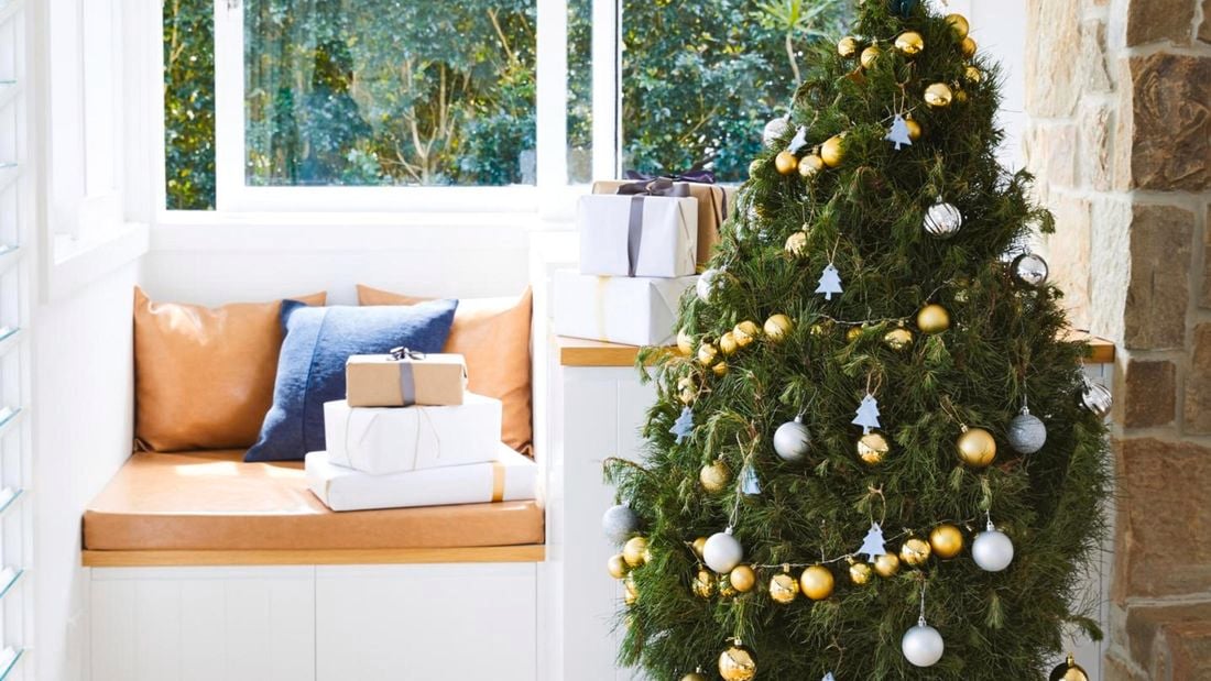 A Christmas tree with a number of wrapped presents in the background