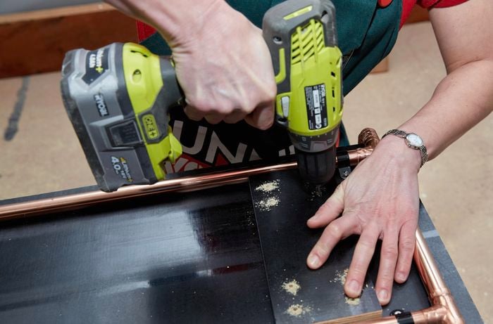 Person drilling into ply