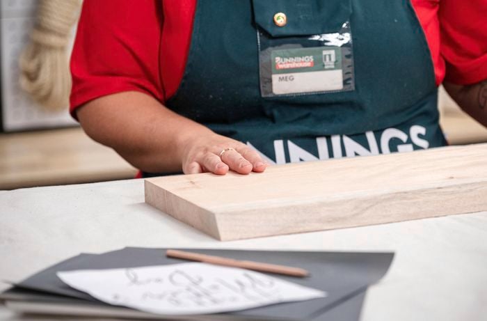 A woman is keeping her hands on a piece of wood.