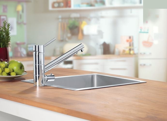 Kitchen benchtop with stainless steel sink and tapware