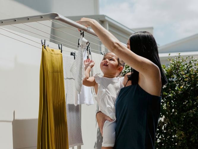 Mother and child hanging washing on a Hills Double Folding Frame Clothesline.