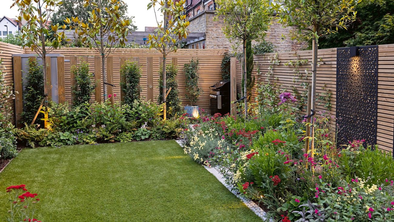 Fenced backyard with lawn, plants and outdoor barbeque