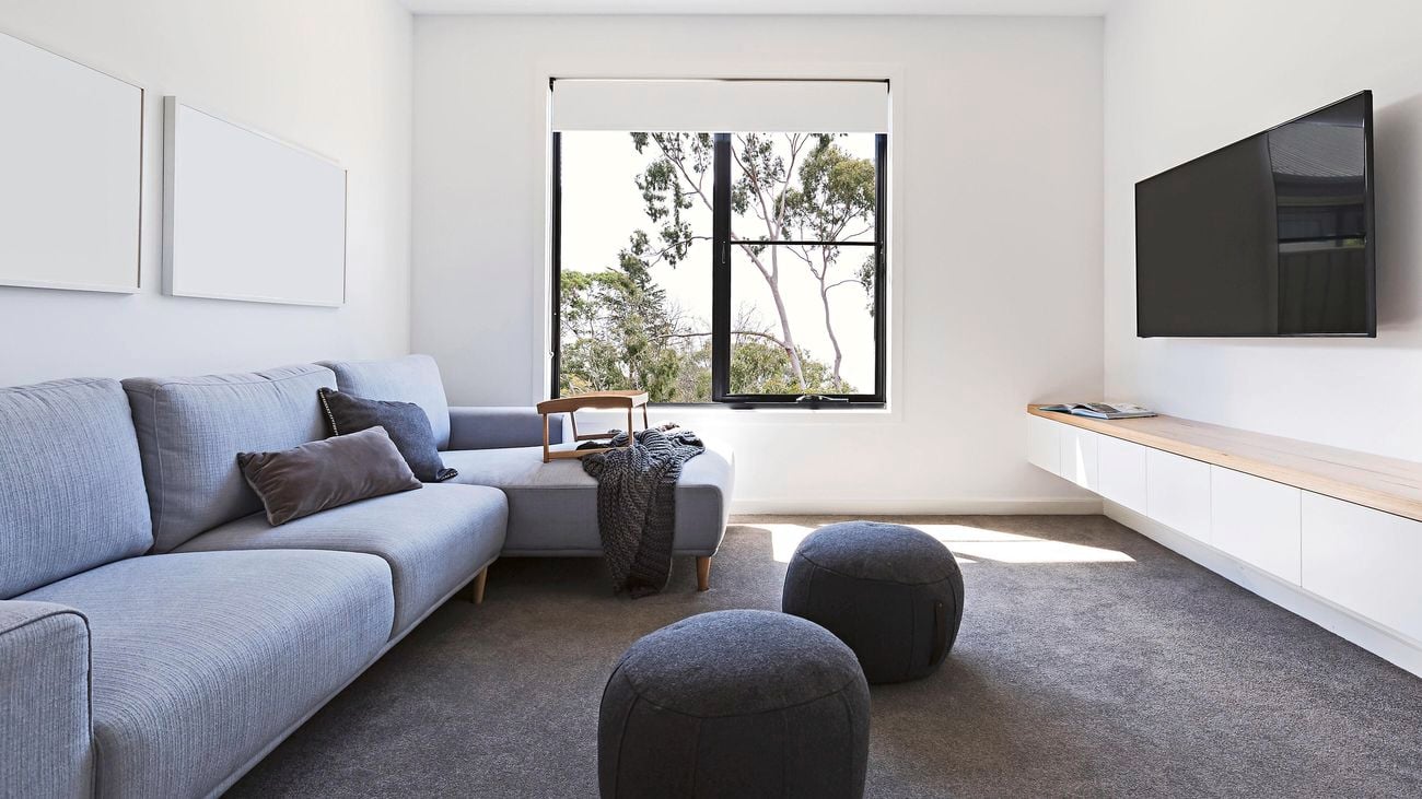 Modern living room with modular couch and flat screen tv mounted on the wall