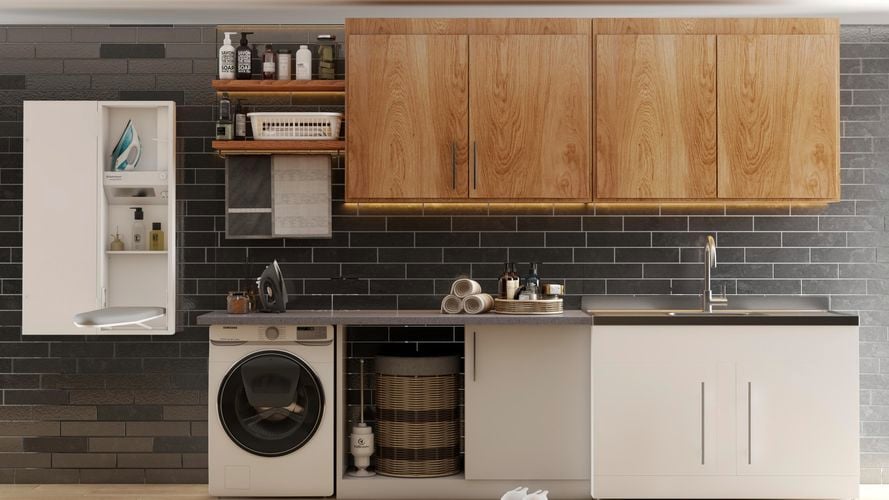Dark laundry with a wall mounted ironing board, supertub, washing machine, storage, timber look cabinets and black subway wall tiles
