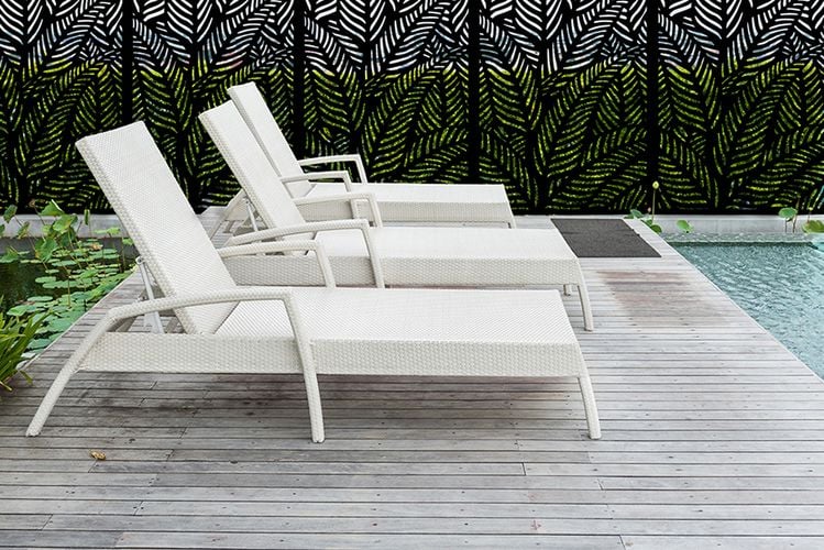 Decking by pool with three lounge chairs and decorative screens