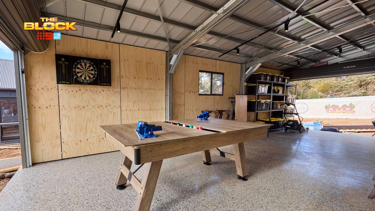 A garage with a saw on a wooden table in it.
