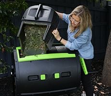 Person emptying lawn clippings into compost bin