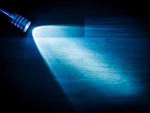 Lamp shining light on a desk.