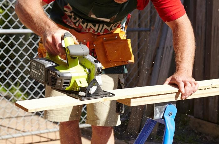 A circular saw being used to cut timber fence palings to length