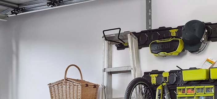 Wall covered in hanging plates and hooks for storing tools.