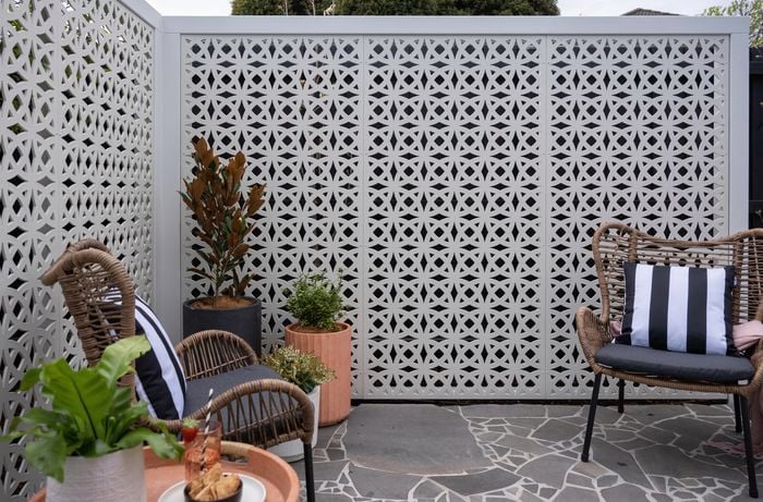 Outdoor chair and table setup with metal screen.