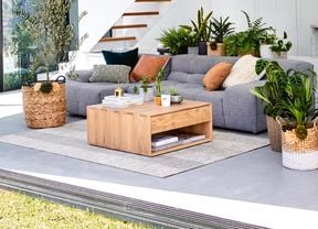 Modern living area with grey sofa, white walls and staircase opening onto grassed area