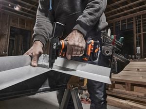 Tradie using AEG rivet gun on metal guttering in house contruction site