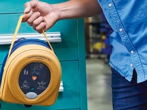 Man holding a HeartSine defibrillator.